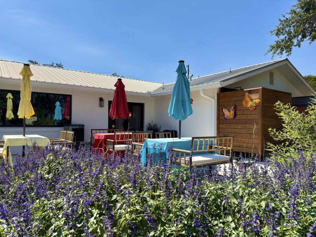 Back porch at Adoration with lavender, patio umbrellas and butterfly wall art