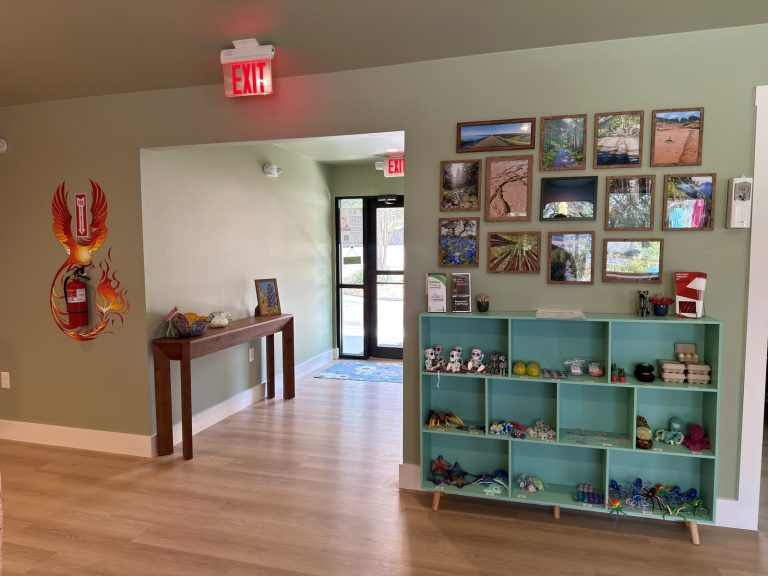 Adoration entrance with a gallery wall of nature photos and a welcome table