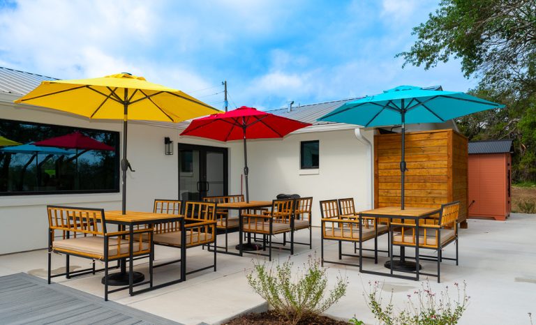 Adoration back patio with umbrellas and seating