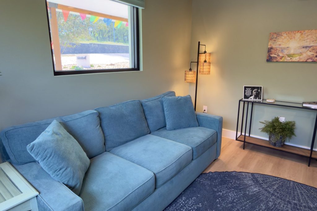 Quiet Adoration therapy room with a blue sofa and soft lighting